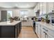 Modern kitchen with white cabinets, stainless steel appliances, and a center island at 6099 N Netherland Ct, Aurora, CO 80019