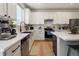 Bright kitchen features white cabinetry, stainless steel appliances, and marble countertops at 6099 N Netherland Ct, Aurora, CO 80019