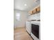 Well-lit laundry room features modern washer and dryer, shelving for storage, and a window at 6099 N Netherland Ct, Aurora, CO 80019