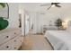 Bright main bedroom with wood floors, ceiling fan, and light wood dresser at 6099 N Netherland Ct, Aurora, CO 80019