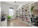 Home office space with built-in white bookshelves, a large window, and wood floors at 6099 N Netherland Ct, Aurora, CO 80019