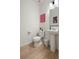 Modern powder room with pedestal sink, contemporary lighting, and wood grain floors at 6099 N Netherland Ct, Aurora, CO 80019