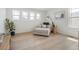 Cozy sitting room offers hardwood floors, natural light, and a comfortable chaise lounge with views from three windows at 6099 N Netherland Ct, Aurora, CO 80019