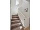 Staircase leading to the upper level is painted white with light carpeted stairs and a window at 6099 N Netherland Ct, Aurora, CO 80019