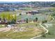 Expansive aerial view showcasing the park, football field, neighborhood, and scenic landscape at 18 Brixham Ct, Castle Pines, CO 80108