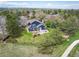 Aerial view of blue house with lush backyard, fire pit, and beautiful neighborhood scenery at 18 Brixham Ct, Castle Pines, CO 80108