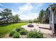 Picturesque backyard features a stone fire pit, lush greenery, and a partial view at 18 Brixham Ct, Castle Pines, CO 80108