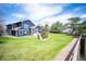 Expansive backyard showcases a spacious lawn, mature trees, and direct access from the home at 18 Brixham Ct, Castle Pines, CO 80108