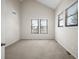 Neutral bedroom with vaulted ceilings, large windows and neutral colored carpet at 18 Brixham Ct, Castle Pines, CO 80108