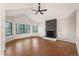 Spacious living area with hardwood floors, large windows, and a painted brick fireplace at 18 Brixham Ct, Castle Pines, CO 80108
