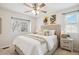 Bright bedroom featuring a queen bed, ceiling fan, and ample natural light from two windows at 1470 S Quebec Way # 178, Denver, CO 80231
