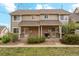 Charming townhome exterior featuring a well-maintained lawn, lush landscaping, and a welcoming front porch at 1470 S Quebec Way # 178, Denver, CO 80231