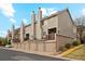 Exterior view of townhomes with attached garages, brick accents, and manicured landscaping at 1470 S Quebec Way # 178, Denver, CO 80231