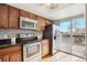 Galley kitchen boasts stainless steel appliances, wood cabinets and access to the deck at 1470 S Quebec Way # 178, Denver, CO 80231
