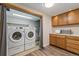 Well-equipped laundry room with modern washer and dryer, oak cabinets and a countertop at 1470 S Quebec Way # 178, Denver, CO 80231