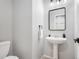 Clean bathroom with pedestal sink, mirror, and modern fixtures at 12826 W Brittany Dr, Littleton, CO 80127