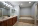 Bathroom with double vanity, large tub, and tile flooring at 12826 W Brittany Dr, Littleton, CO 80127