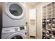 Well-organized laundry area featuring a stacked washer and dryer and lots of storage space at 12826 W Brittany Dr, Littleton, CO 80127