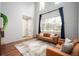 Elegant living room featuring high ceilings, large windows, and a comfortable seating arrangement at 12826 W Brittany Dr, Littleton, CO 80127