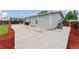Spacious backyard with concrete patio, lush green grass, privacy fence, and a mulched flower bed border at 687 Prairie Ave, Brighton, CO 80603