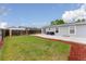 Expansive backyard features a grassy lawn, concrete patio with grill and dining set, and privacy fencing at 687 Prairie Ave, Brighton, CO 80603