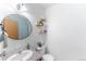 Neat bathroom with sink, toilet, and stylish decorative shelves, illuminated by a contemporary light fixture at 687 Prairie Ave, Brighton, CO 80603