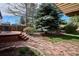 Backyard featuring deck with seating, mature trees, and stone walkway at 13183 Spica Dr, Lone Tree, CO 80124