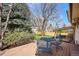 Backyard featuring deck with seating, mature trees, and manicured lawn at 13183 Spica Dr, Lone Tree, CO 80124