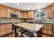 Charming kitchen with wooden cabinets, stainless steel appliances, and a decorative tile backsplash at 13183 Spica Dr, Lone Tree, CO 80124