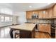 Open concept kitchen with a large island, stainless steel appliances, and hardwood floors leading to the living room at 13183 Spica Dr, Lone Tree, CO 80124