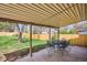 Covered patio with concrete floor has a table and chairs and overlooks the large, green backyard at 13183 Spica Dr, Lone Tree, CO 80124
