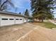 Home featuring a two-car garage and a well-kept front yard with mature trees at 2900 S Downing St, Englewood, CO 80113
