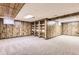 This is a spacious basement with decorative paneling, carpet, and built-in shelving at 13940 E Linvale Pl, Aurora, CO 80014