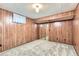 This is a carpeted room in the basement with decorative wood paneling and a mirrored closet at 13940 E Linvale Pl, Aurora, CO 80014