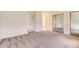 This is a bedroom with carpet, mirrored sliding closet doors, and a door leading to the bathroom at 13940 E Linvale Pl, Aurora, CO 80014