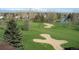 Scenic aerial view of a lush golf course with sand traps, manicured greens, and mature trees at 13940 E Linvale Pl, Aurora, CO 80014
