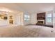 Bright living room featuring a brick fireplace and views into the kitchen at 13940 E Linvale Pl, Aurora, CO 80014