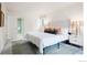 Bright bedroom featuring a tufted headboard, stylish nightstands, and a neutral-toned rug over soft carpet at 3452 S Eagle St # 101, Aurora, CO 80014