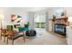 Bright living room featuring a stone fireplace, an emerald green velvet couch, and balcony access at 3452 S Eagle St # 101, Aurora, CO 80014