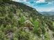 Aerial view of a home nestled in a mountainous, wooded area, offering a serene and private setting at 34127 Cactus Dr, Evergreen, CO 80439