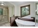 Relaxing bathroom with freestanding tub, glass shower, and scenic window view at 34127 Cactus Dr, Evergreen, CO 80439