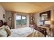 Comfortable bedroom with scenic views, a warm ambiance, and a cozy bed complemented by natural light and furnishings at 34127 Cactus Dr, Evergreen, CO 80439