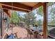 Relaxing deck area features a table set with chairs and a swing, all with views of the lush greenery at 34127 Cactus Dr, Evergreen, CO 80439