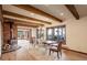 Charming dining room features exposed beams, wood floors, fireplace, and scenic outdoor views at 34127 Cactus Dr, Evergreen, CO 80439