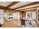 Spacious dining area and kitchen featuring exposed beams, hardwood floors, and an open layout at 34127 Cactus Dr, Evergreen, CO 80439