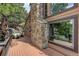 Charming exterior featuring a stone chimney, wood siding, and spacious deck with scenic views of the surrounding landscape at 34127 Cactus Dr, Evergreen, CO 80439