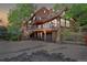 Stunning multi-level home featuring wood siding, large deck, and a stone garage, nestled in a scenic wooded landscape at 34127 Cactus Dr, Evergreen, CO 80439