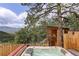Backyard hot tub and spa area with natural views and an adjacent sauna at 34127 Cactus Dr, Evergreen, CO 80439