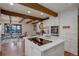 Open kitchen and dining area with exposed beams and hardwood floors, perfect for entertaining at 34127 Cactus Dr, Evergreen, CO 80439