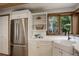 Well-lit kitchen with stainless steel appliances, white cabinets, and a farmhouse-style sink at 34127 Cactus Dr, Evergreen, CO 80439